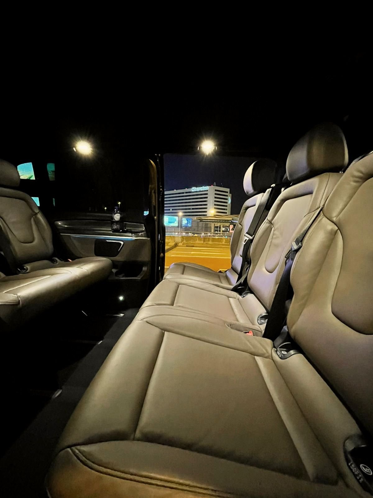 Rear seats inside a van at night, with the side door open